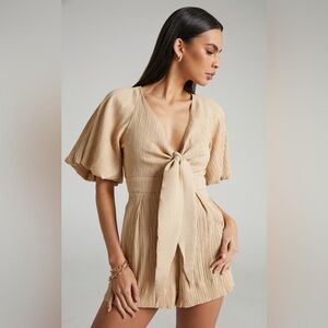 Showpo CELESTIA PLAYSUIT - PLUNGE TIE FRONT PUFF SLEEVE PLAYSUIT IN SAND